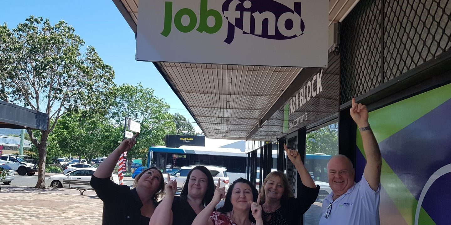 Jobfind Dapto - image of five smiling and pointing to Jobfind office sign