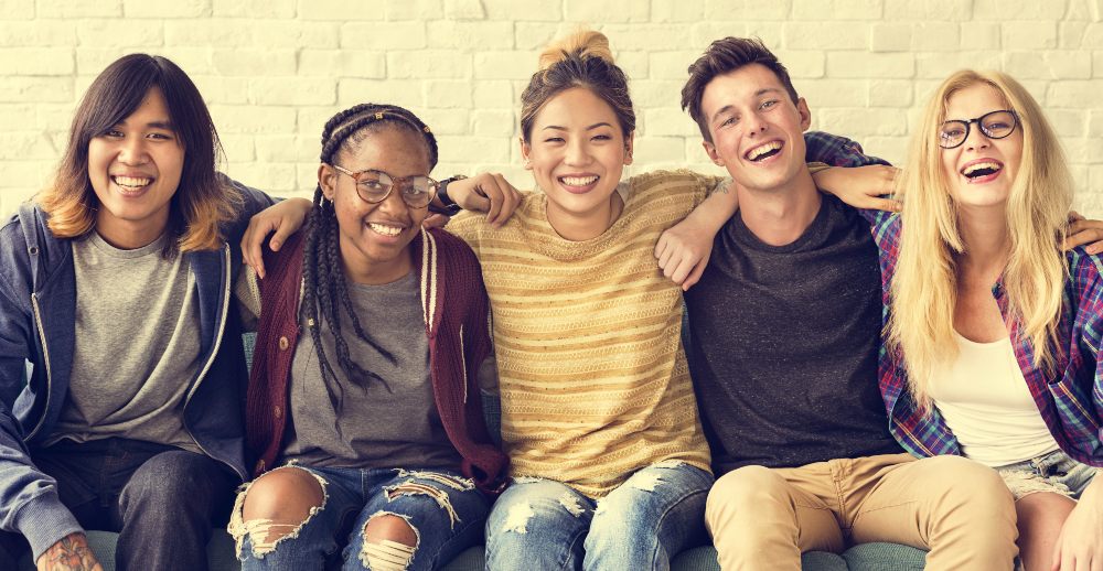 youth employment consortium - image of five young people seated with arms around each others' shoulders and smiling widely