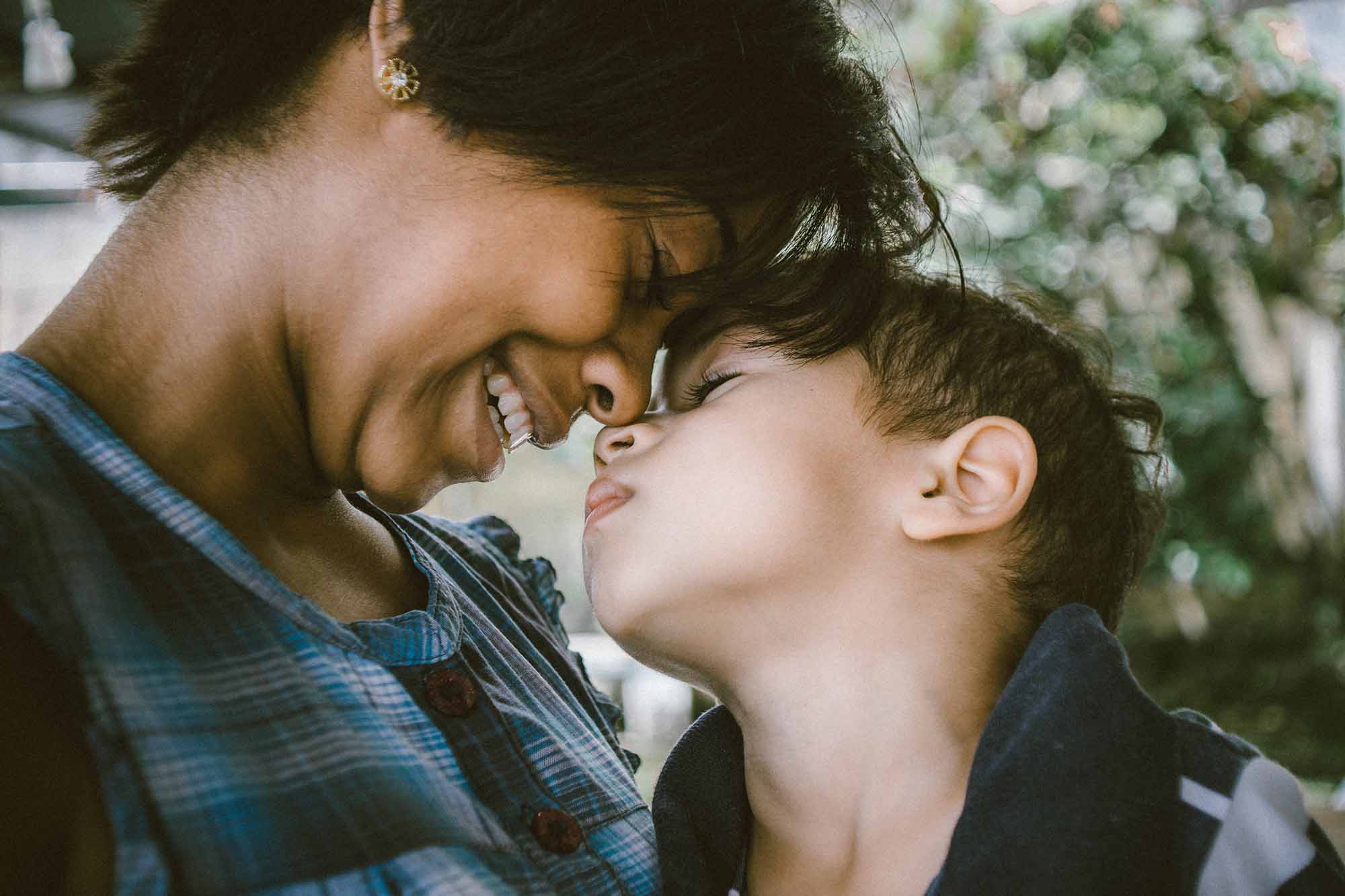 Jobfind-Ganeesha’s Story - image of a woman smiling and leaning down to touch her face to a young boy's face