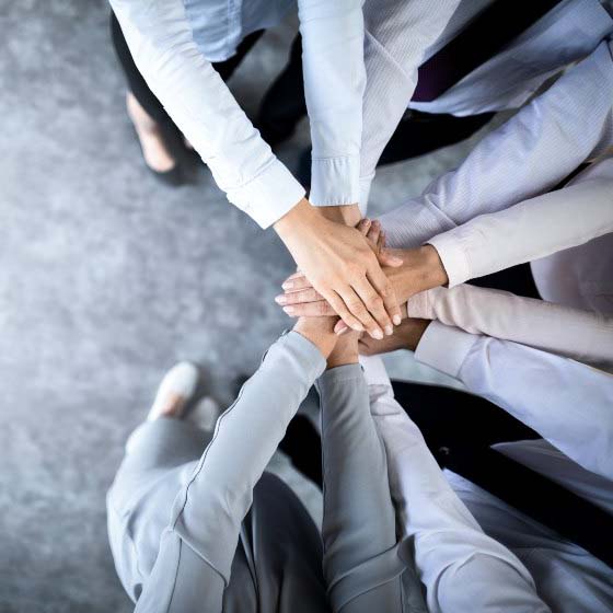 Jobfind Programmed Partnership - image taken from above of a group of people's arms putting hands on top of each other