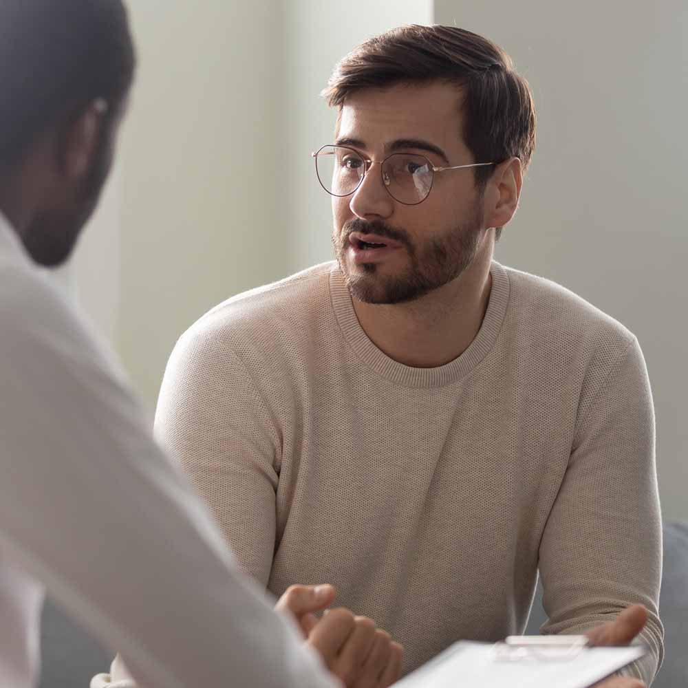 Staff wellbeing and support - image of seated man talking to a man opposite him