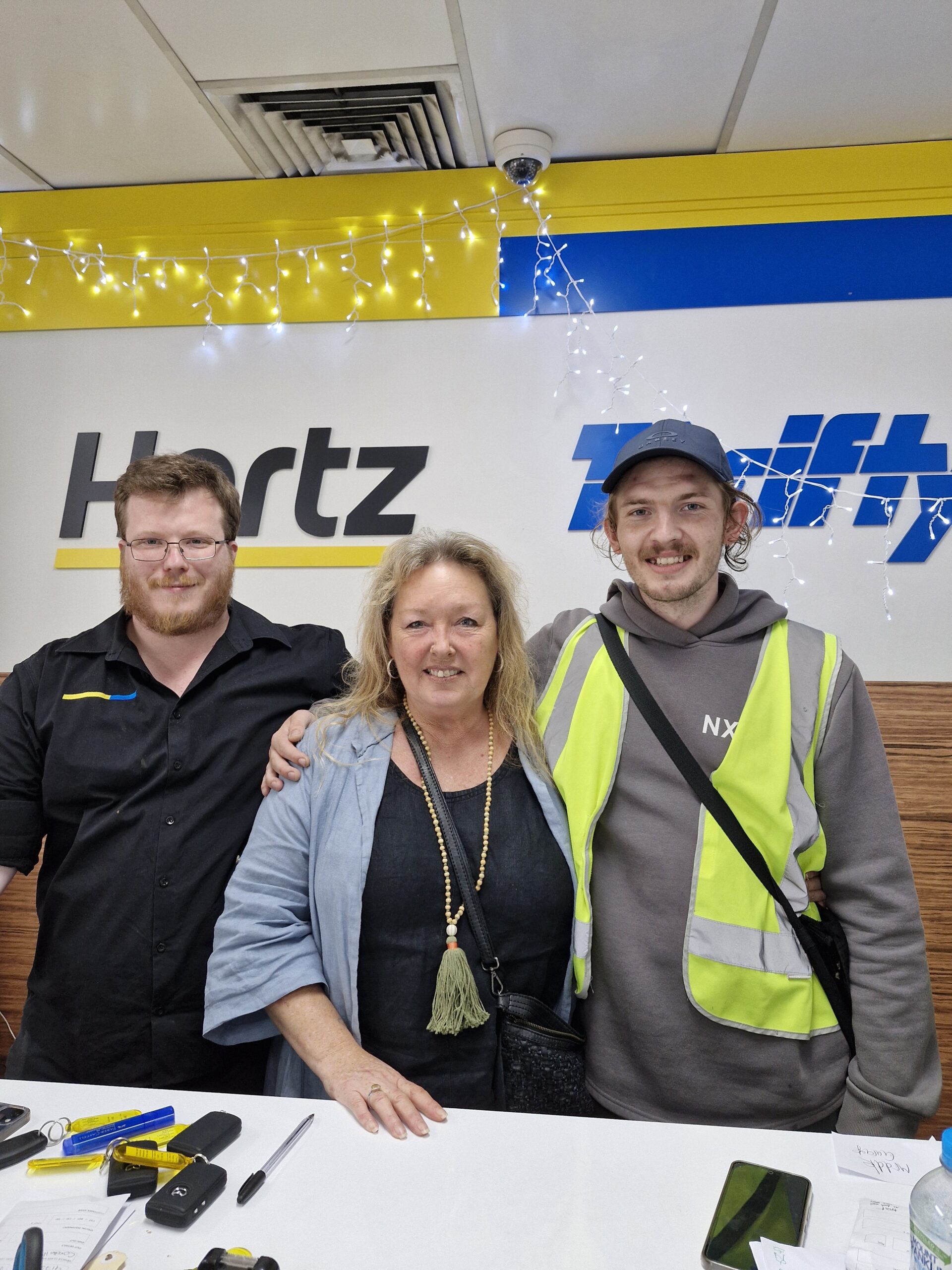 Blake Miles Manager at Hertz pictured with Jobfind participant Reilly and Jobfind Employment Consultant Maree. All three are pictured standing and smiling at the camera.